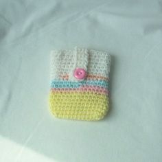 a small crocheted cell phone case with a button on the front and side