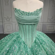 Experience a dream come true with this luxurious mint green Quinceanera ball gown. The corset style beaded bodice is reminiscent of an old west saloon, with intricate bead work adorning the top. A princess V waist and heavily beaded, sequined full skirt create an exquisite silhouette. Complete with a train and ribbon tie lace up back, for a customizable fit. material: organza color: as shown type: party ball gown fitted bodice built in bra scalloped neckline lace up back court train shown as size 2 Green Quinceanera Dress, Quinceanera Dances, Gown Fitted, Beaded Ball Gown, Green Quinceanera, Green Quinceanera Dresses, Champagne Quinceanera Dresses, Quinceanera Themes Dresses, White Quinceanera Dresses