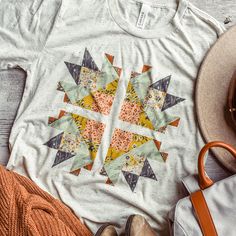 a t - shirt that has an orange and yellow design on it, next to some other items