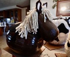 a horse made out of chocolate sitting on top of a kitchen counter next to cow sculptures