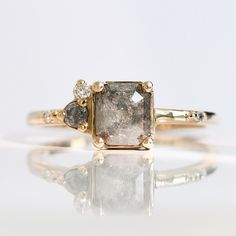 a diamond ring with three diamonds on it's sides and one stone in the middle