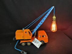 an orange toy truck with a light bulb attached to it