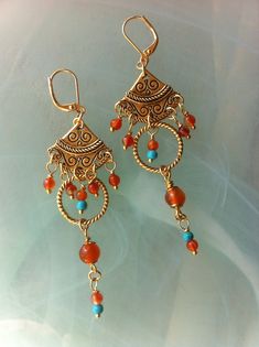 Earrings in an ethnic bohemian style composed of engraved gold-plated fans and twisted rings, Carnelians and Turquoises. Two measuring fans and two closed twisted rings measuring 17 mm in diameter. Cornalines of 6 mm and 3 mm, small Turquoises of 3 mm. Gold plated hooks with lever-back. These earrings measure 8 cm or 3 inches from top to bottom. Hippie Earrings, Twist Ring, Star Earrings, Bohemian Style, Hippie Boho, Jewelry Earrings Dangle, Etsy Gifts, Dangle Drop Earrings, Dangle Earrings