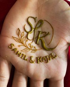 a person's hand with gold lettering on it and the word sr still & koran written in cursive letters