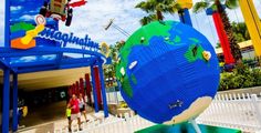 a giant lego globe in front of the entrance to an amusement park