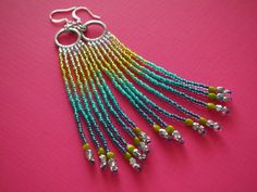 "WAS $35 now $26.25 need a winter pick-me-up? try out these breezy, tropically-colored beaded earrings. i stitched Toho seed beads to 15mm antique silver plated ring elements. silver fades into lime green, teal shades, and then dark capri blue. the fringes are tipped with lime green \"pinch\" beads and brilliant Firepolish Czech glass. though they dangle 4 inches long from delicate silver plated earring hooks, they are lightweight and comfortable." Colorful Summer Jewelry With Dangling Beads, Summer Rainbow Jewelry With Dangling Beads, Colorful Summer Dangle Jewelry, Turquoise Dangle Jewelry For Spring, Rainbow Bohemian Jewelry For Spring, Bohemian Rainbow Jewelry For Spring, Vibrant Turquoise Jewelry For Summer, Spring Rainbow Bohemian Jewelry, Summer Silver Jewelry With Colorful Beads