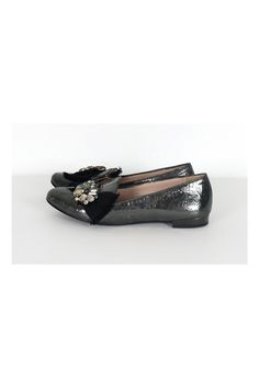 The leather of these flats has a unique crackled look. A bold rhinestone and ribbon design adorns the front. These luxe flats have all of the shimmer and glam you need. Size 6.5 (EU 36.5) Leather upper, lining & sole Made in Italy Rounded toe Crackled look to leather Rhinestone detail on front w/ ribbon Mirrored design on heel Light scuffs on toe Some outsole wear Outsole length 10" Elegant Evening Ballet Flats With Textured Sole, Evening Ballet Flats With Textured Sole, Party Loafers With Almond Toe Slip-on, Textured Sole Ballet Flats For Evening, Silver Closed Toe Ballet Flats For Party, Evening Slip-on Ballet Flats, Embellished Leather Ballet Flats With Flat Heel, Silver Ballet Flats For Party With Round Toe, Leather Embellished Ballet Flats