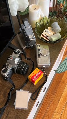 there are many items on the table including cameras, candles and other things to buy