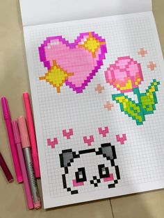 a piece of paper with some pixel art on it and three markers next to it