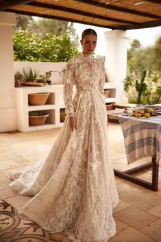 a woman in a wedding dress standing on a patio