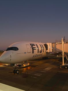 an airplane is parked on the tarmac at night