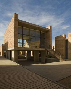 the building has many windows on it and is made out of wood, with stairs leading up to the second floor