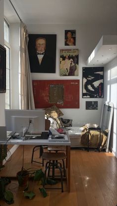 a living room filled with furniture and pictures on the wall above it's desk