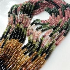 multicolored beads are arranged on a white surface