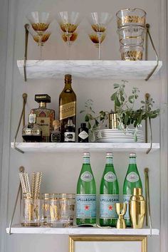 the shelves are filled with glasses, bottles and other things to drink from them on