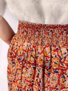 This midi skirt features a tie front and elastic waistband in back for the perfect style and comfort combo. The standout of this pull-on skirt is its gorgeous hand block printed fabric with red, orange, and blue tones. Fit Note: True to size 100% cotton Hand block printed Elastic smocking at back waist Self ties at front Length of size M is 32" Made fair trade in India by one of our longstanding production partners This fabric has been hand printed. Please allow for unique variations in color, t Hand Embroidered Skirt, Mandarin Collar Shirt, Neutral Accessories, Block Printed Fabric, Fair Trade Clothing, Colored Tights, Embroidered Skirt, Block Printing Fabric, Perfect Style