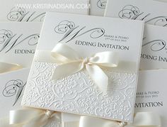 wedding cards with white ribbons and bows on them