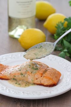 a white plate topped with salmon covered in sauce