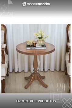 a small table with flowers on it in front of curtains