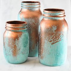 three copper and blue mason jars sitting next to each other