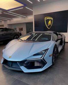 a blue sports car is parked in a showroom