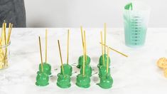 there are many green candies with gold sticks sticking out of them on the table