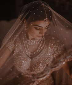 a woman in a wedding dress with a veil over her head and water droplets on her face