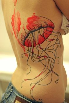 a woman's stomach with a jellyfish tattoo on her side and the bottom part of her body painted red