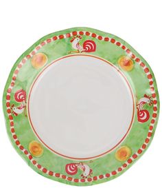 a green plate with red and orange designs on the rim, sitting in front of a white background