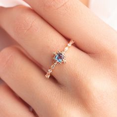 a woman's hand with a ring on it and a blue stone in the middle