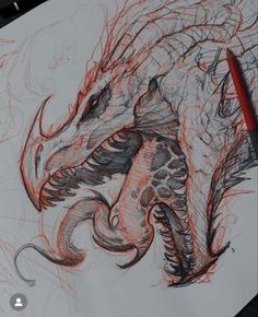 a drawing of a dragon on paper with a red pencil in it's mouth