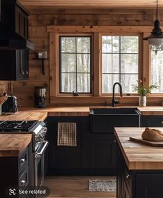 a kitchen with wooden walls and black cabinets