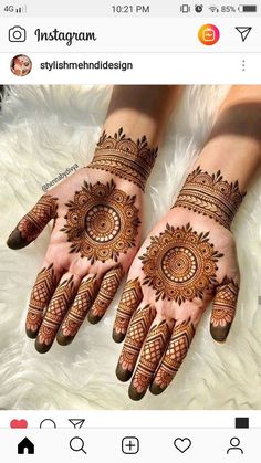 two hands with henna tattoos on them, one is showing off the intricate design