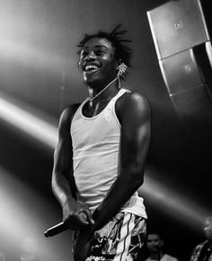 a black and white photo of a man with dreadlocks