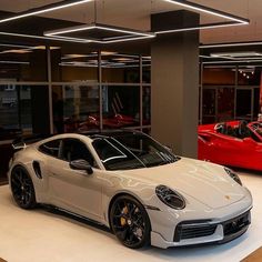 two sports cars are parked in the showroom