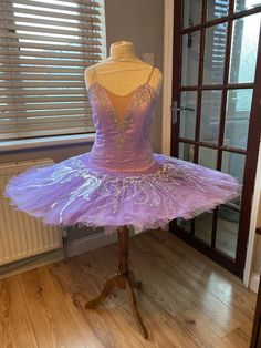 a ballerina's dress on display in front of a window