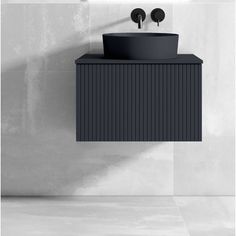 a black sink sitting next to a wall mounted faucet