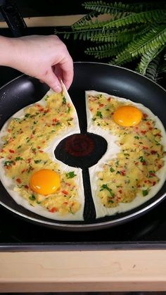 someone is frying eggs in a pan on top of a stove with a spatula