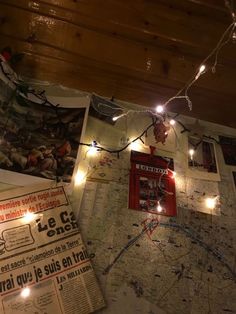 a map with lights hanging from it and some newspaper on the wall next to it