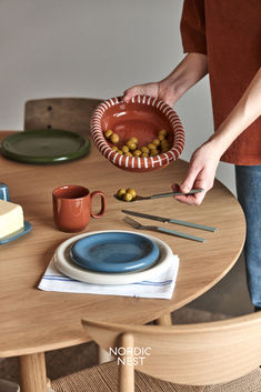 a person holding a plate with food on it and chopsticks in front of them