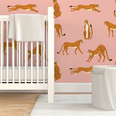 a baby's room with pink wallpaper and giraffes on it