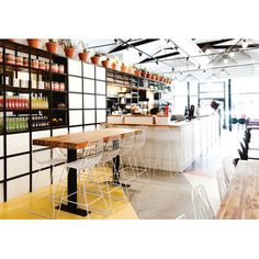 the interior of a restaurant with tables, chairs and shelves full of bottles on display