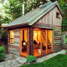 a small wooden cabin with a door open