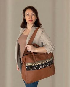 Rug patterned fabric detailed soft real leather brown cognac briefcase laptop bag. There are 8 separate organizer pockets. You can carry all your documents, laptop and daily belongings together. It has separate compartments for laptop, business cards and documents. There are even small pockets specially designed for you to put your fountain pens inside the bag. These laptop briefcase is durable and high quality with lining inside for soft protection. It is a gorgeous gift for birthday, new year and Christmas. It is an unforgettable gift for your co-worker, colleague, manager, girlfriend, sister, wife and anyone else you love. You can personalize this unique design bag by adding a name tag to it. With the laptop briefcase, we send two shoulder straps, one of which is genuine leather and the Cognac Leather Laptop Bag For Office, Cognac Satchel Laptop Bag For Travel, Brown Leather Trim Travel Bag For Business Trips, Brown Leather Trim Weekender Bag For Business, Brown Leather Laptop Bag For Work, Luxury Brown Shoulder Bag With Laptop Sleeve, Brown Business Laptop Shoulder Bag, Brown Shoulder Laptop Bag For Business, Brown Leather Trim Office Bag