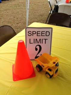 there is a sign that says speed limit on the table next to a toy dump truck