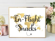 a sign that says in flight snacks next to some flowers and vases on a table