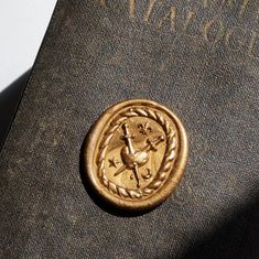 a close up of a book with a gold seal on it