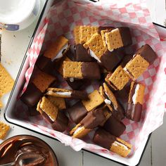 chocolate and marshmallows in a baking dish next to a bowl of dip