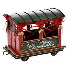 a merry christmas train with red bows on it's roof and the door open