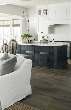 a living room filled with furniture next to a kitchen